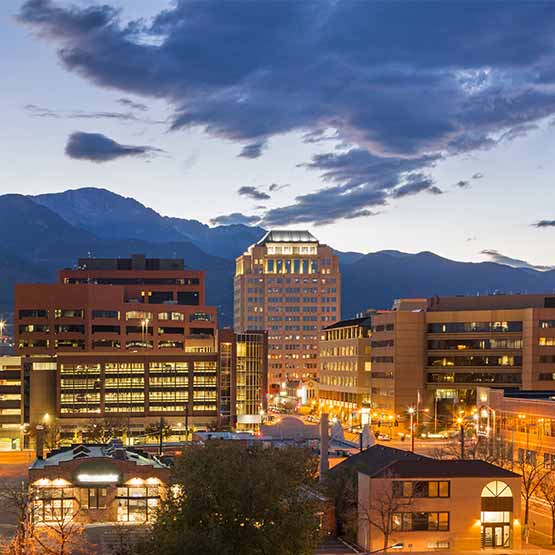 Evening view of the Colorado Springs city skyline with the mountains in the background