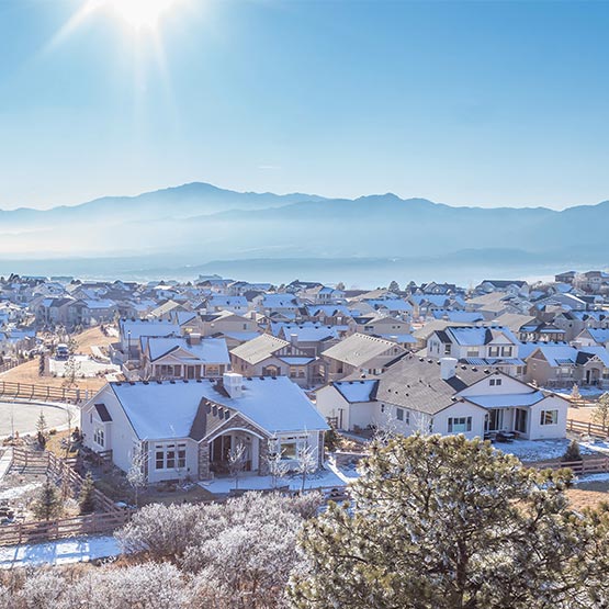 Daytime view of houses on the front range with the mountains in the background