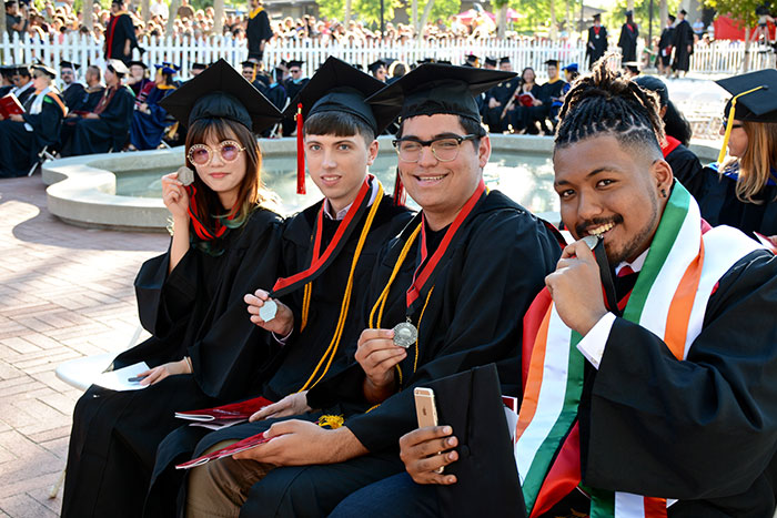 Group of four graduates with medals