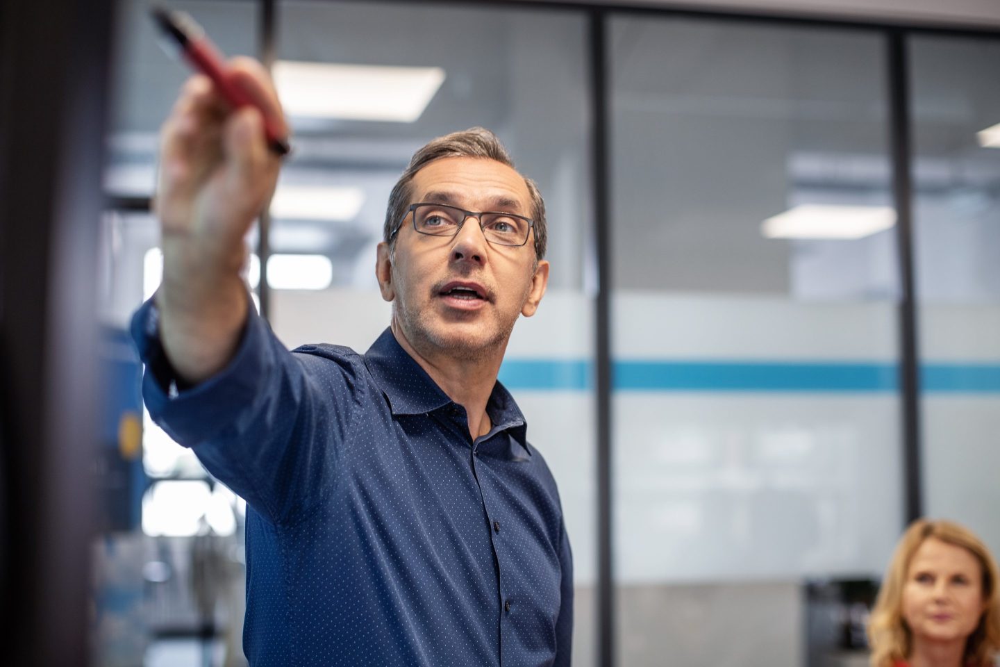 Mature businessman giving presentation during meeting in office