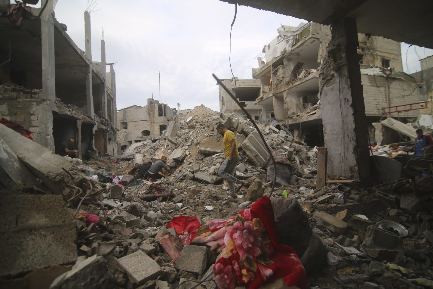 Palestinians inspect rubble in a destroyed refugee camp.