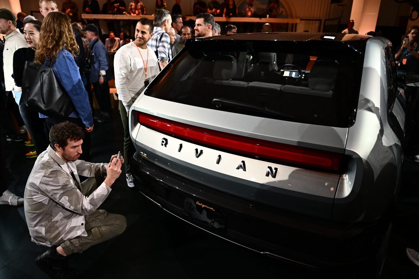 Rivian car surrounded by people