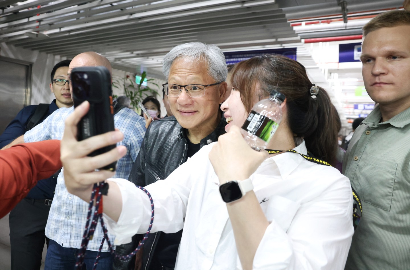 A fan takes a selfie with Nvidia CEO Jensen Huang (C) during Computex 2024 at Taipei Nangang Exhibition Center, in Taipei on June 4, 2024. (Photo by I-Hwa CHENG / AFP) (Photo by I-HWA CHENG/AFP via Getty Images)