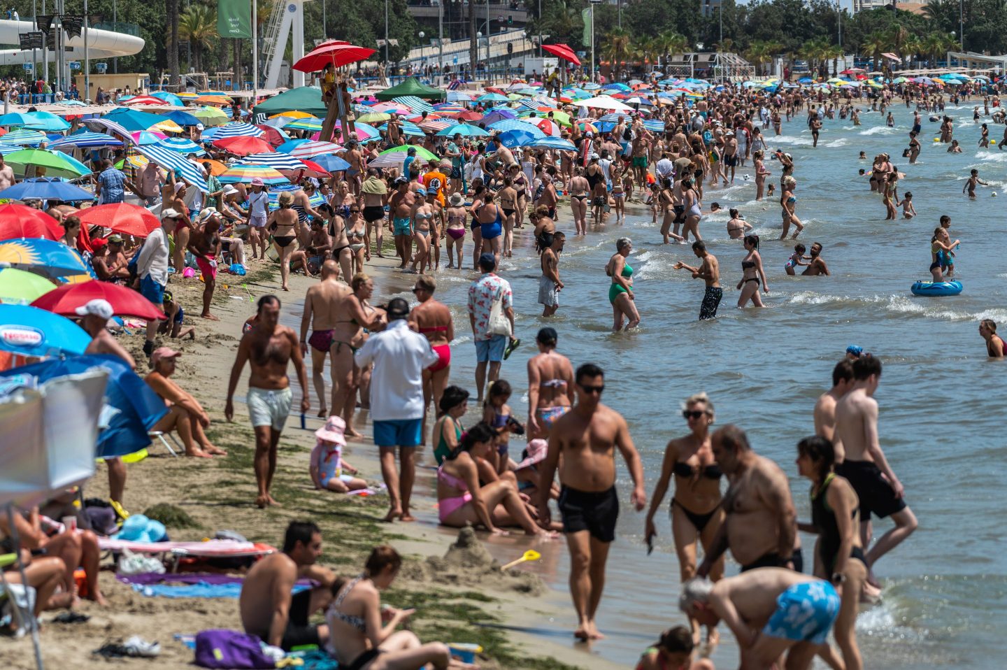 Crowds of tourists and locals cool off at a crowded El Postiguet Beach