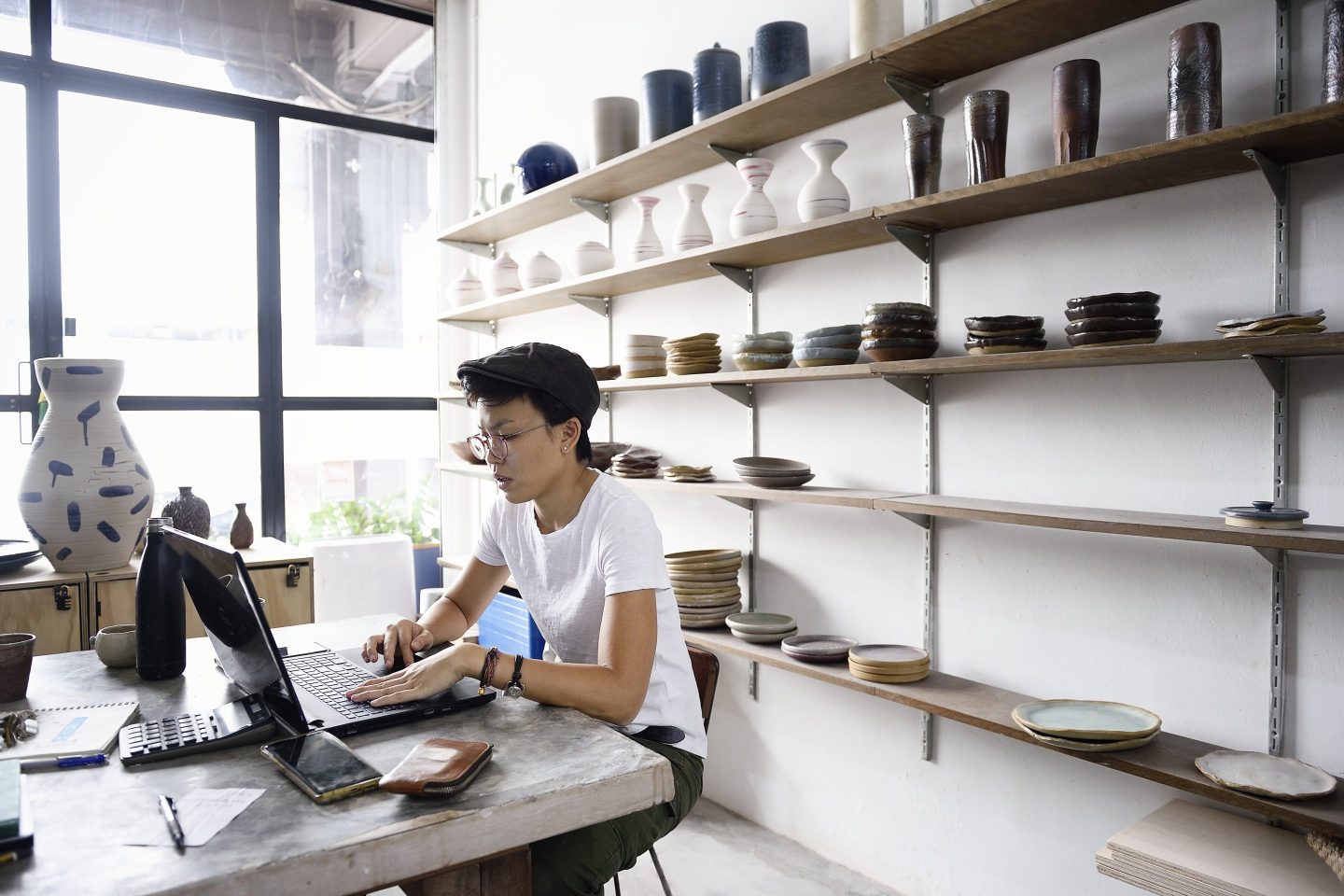 Young entrepreneur working from her laptop in her store.