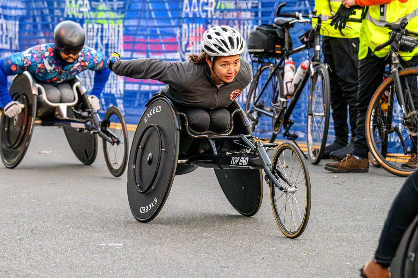 Female athlete in racing wheelchair wearing bike helmet