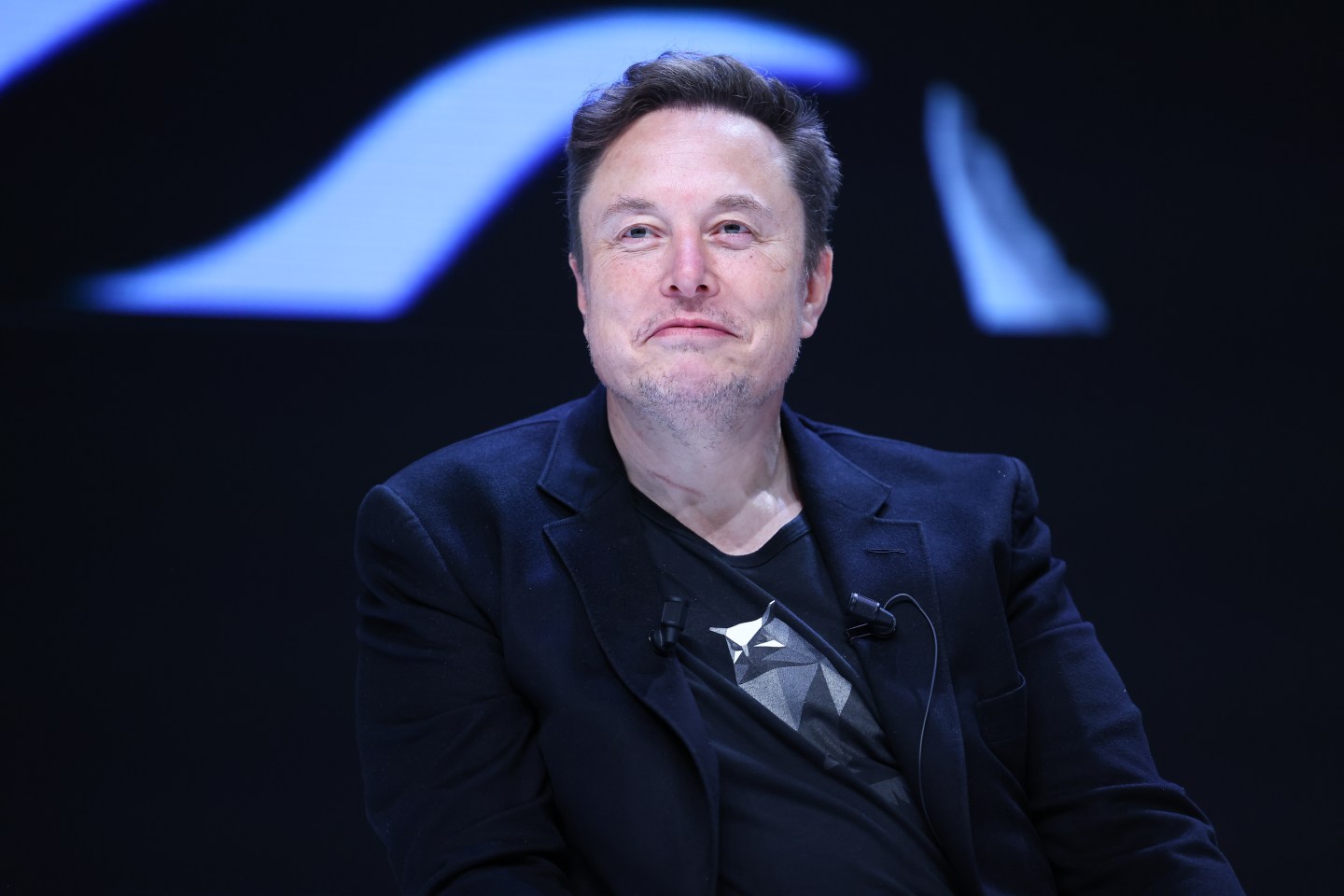 Musk seen from the front smiling.