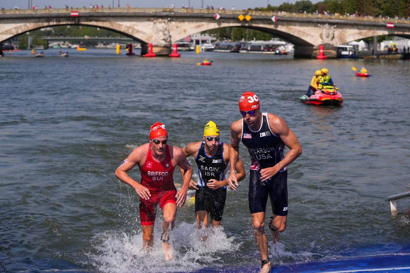 A group of swimmers run out of the Seine river.