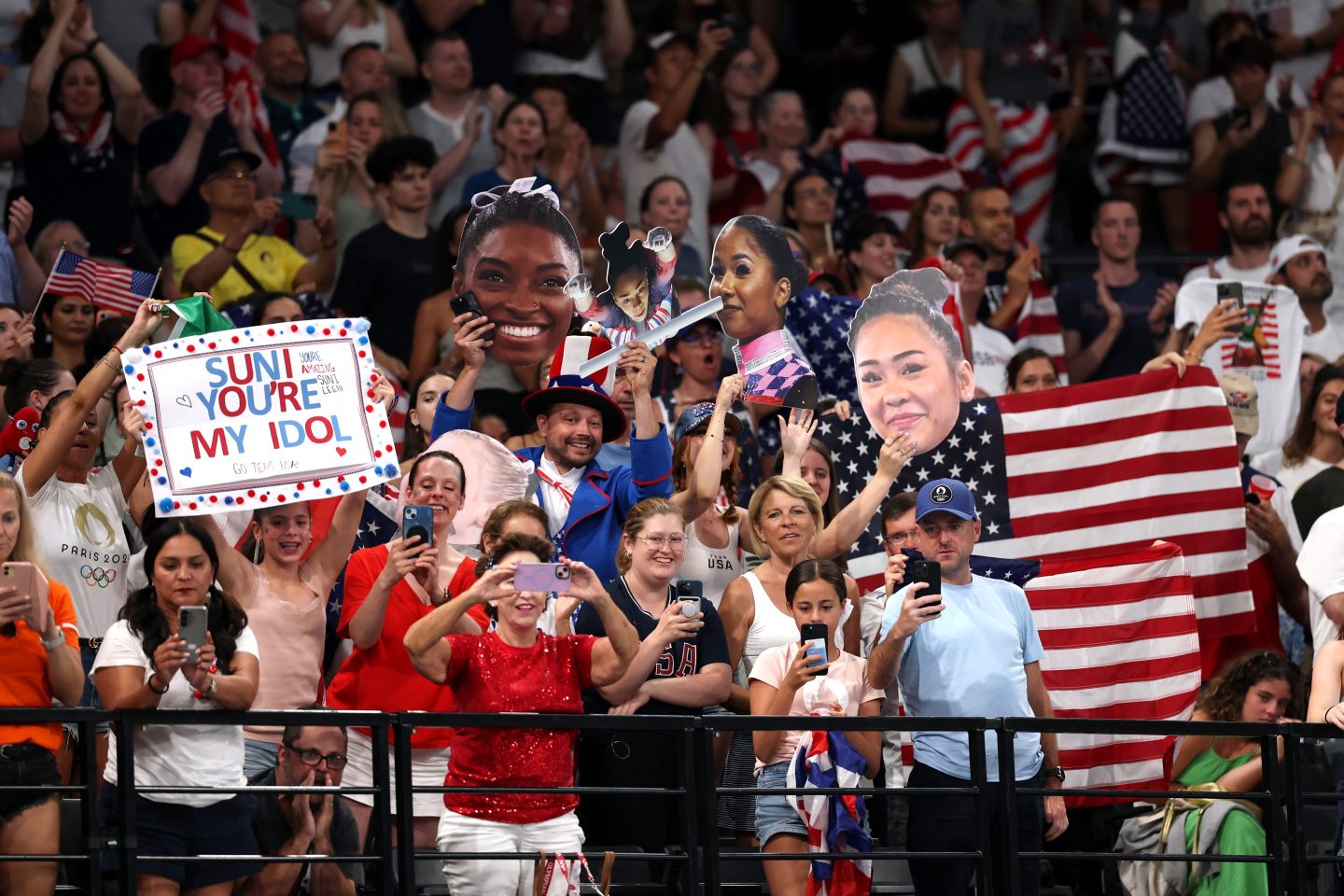 Fans of Team United States cheer and hold signs at the Paris Olympics