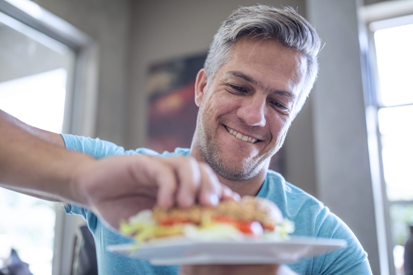 Man picking up a sandwich