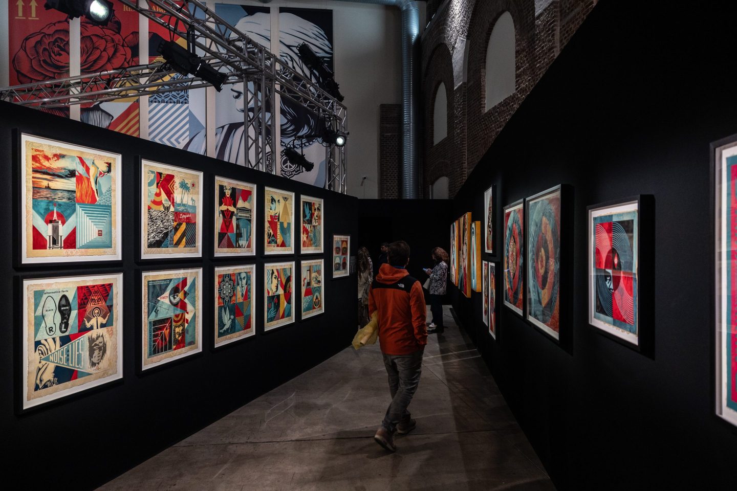 man walks past some artworks while attending the press preview of the exhibition "OBEY: The Art of Shepard Fairey."