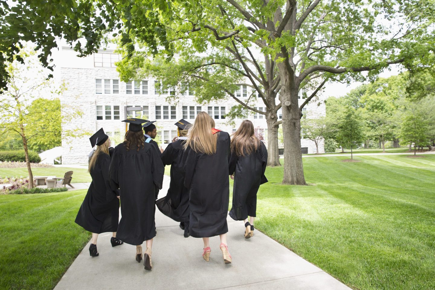 Back view of college graduates walking away.