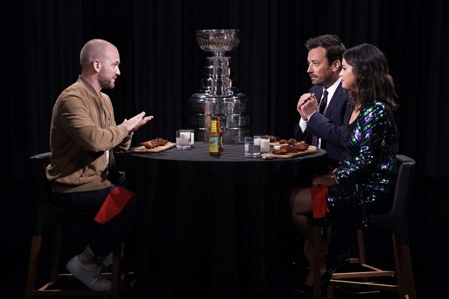 Interviewer Sean Evans, the Stanley Cup, host Jimmy Fallon, and singer Selena Gomez during "Hot Ones" in 2019.