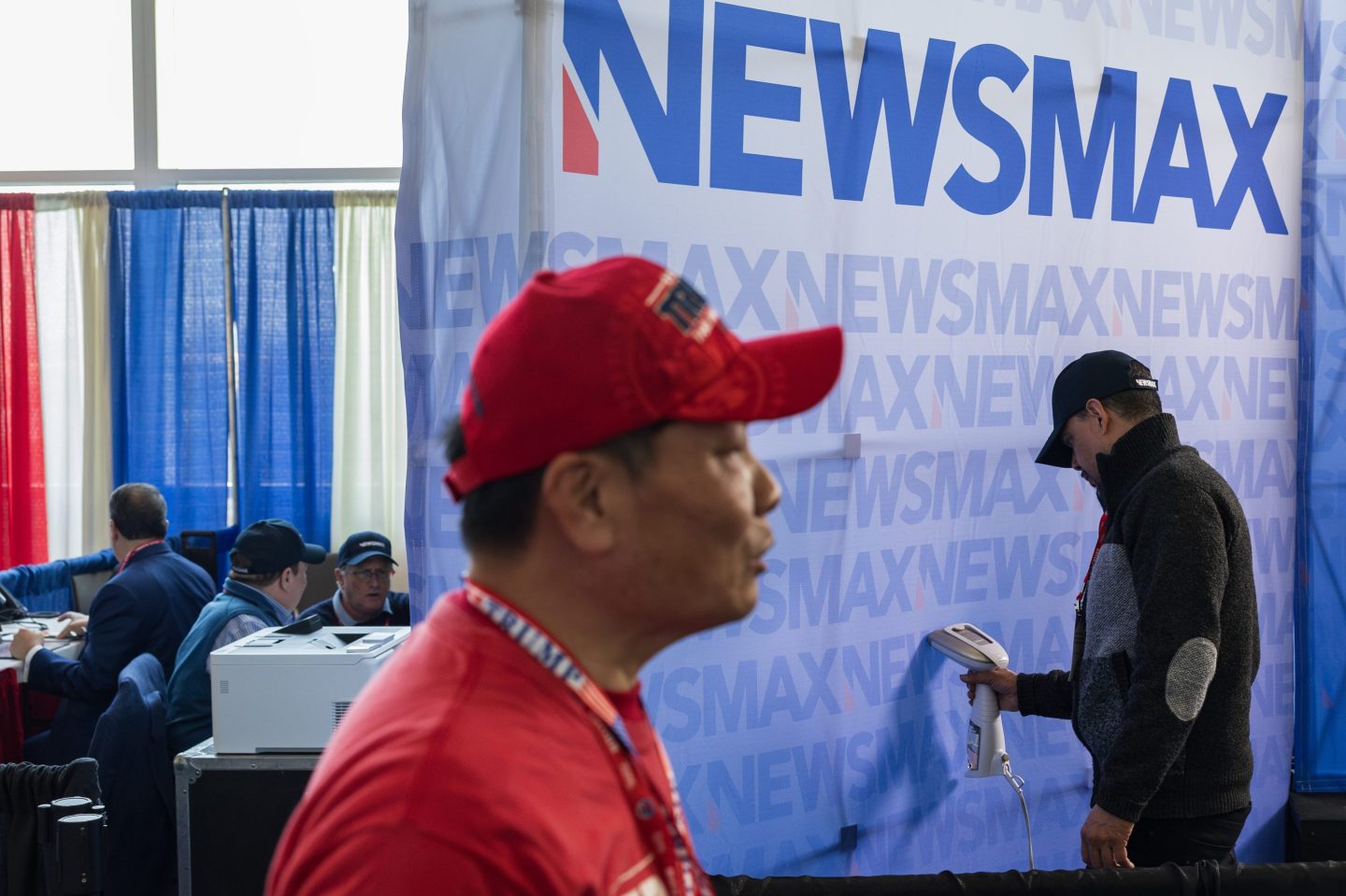 NATIONAL HARBOR, MD &#8211; FEBRUARY 24: A NEWSMAX television crew member steam irons a backdrop during the Conservative Political Action Conference (CPAC) in National Harbor, Maryland, on Saturday, February 24, 2024. (Photo by Tom Brenner for The Washington Post via Getty Images)