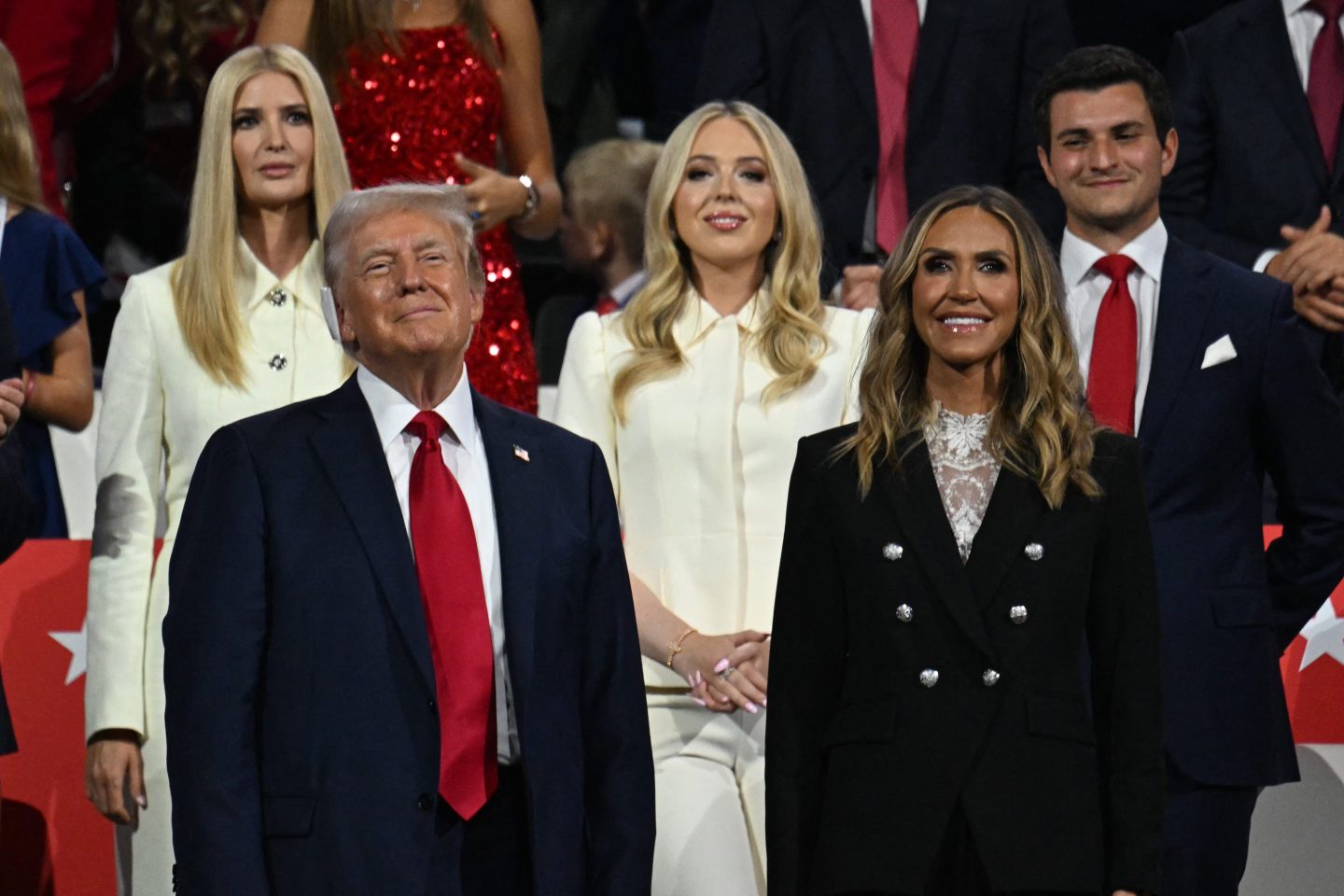 U.S. former President and 2024 Republican presidential candidate Donald Trump (L) stands with Co-chair of the Republican National Committee Lara Trump (R), (from top L) daughter Ivanka Trump, daughter Tiffany Trump and her husband Michael Boulos, during the last day of the 2024 Republican National Convention.