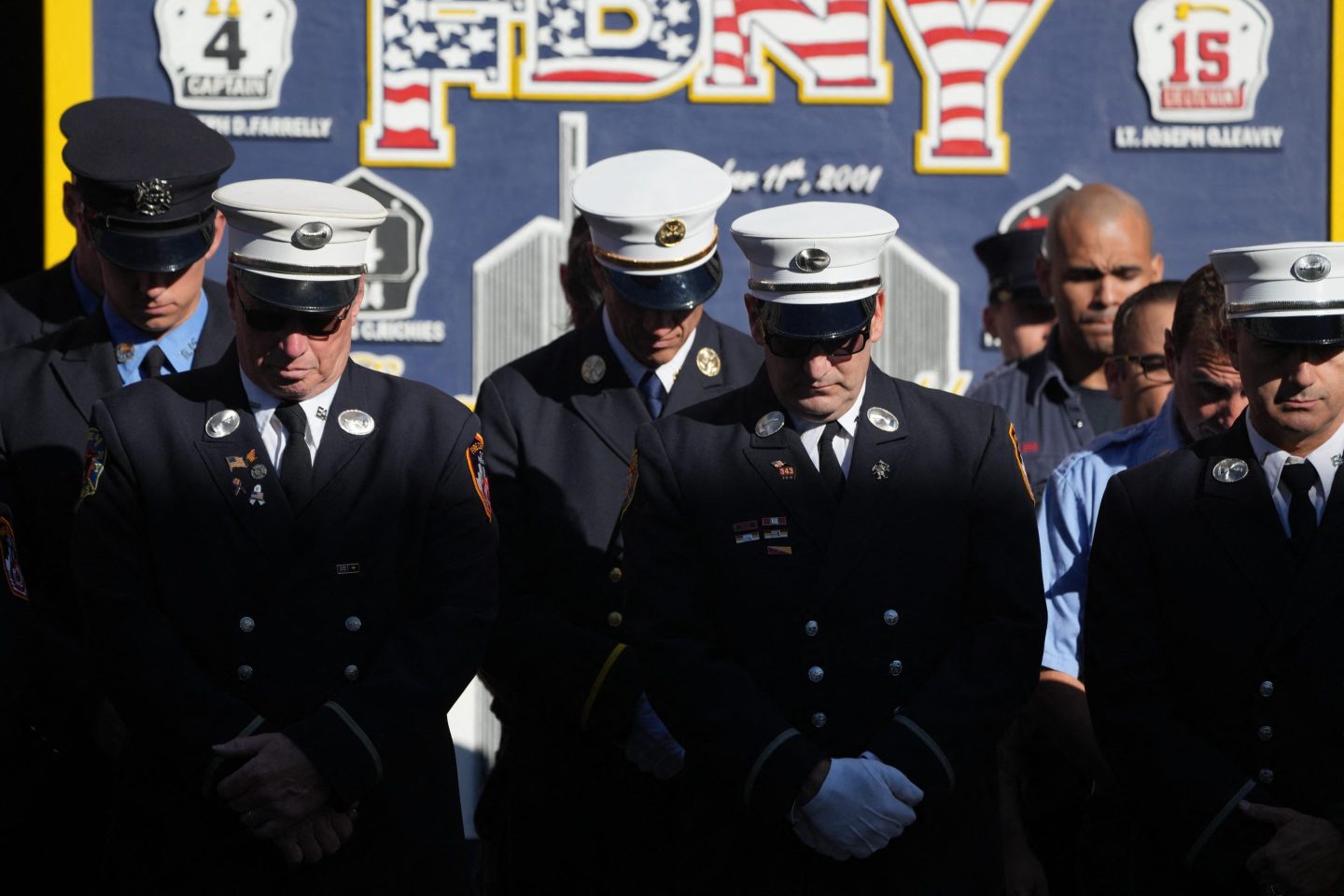 Firefighters pause for a second moment of silence outside FDNY Engine 4/Ladder 15’s firehouse in lower Manhattan on the 23rd anniversary of the 9/11 terrorist attacks in 2001, on Wednesday, Sept. 11, 2024, in New York.