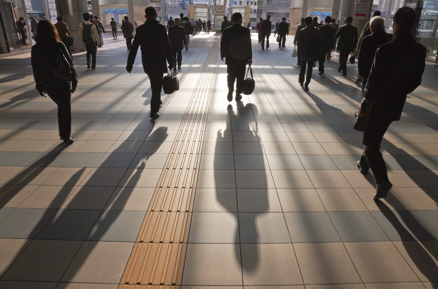 Early morning business commuters flow through the station concourse near the East Exit of Shinagawa Station, located in Tokyo, Japan.