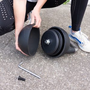 and athlete opening up the bells of steel adjustable kettlebell to change the weights