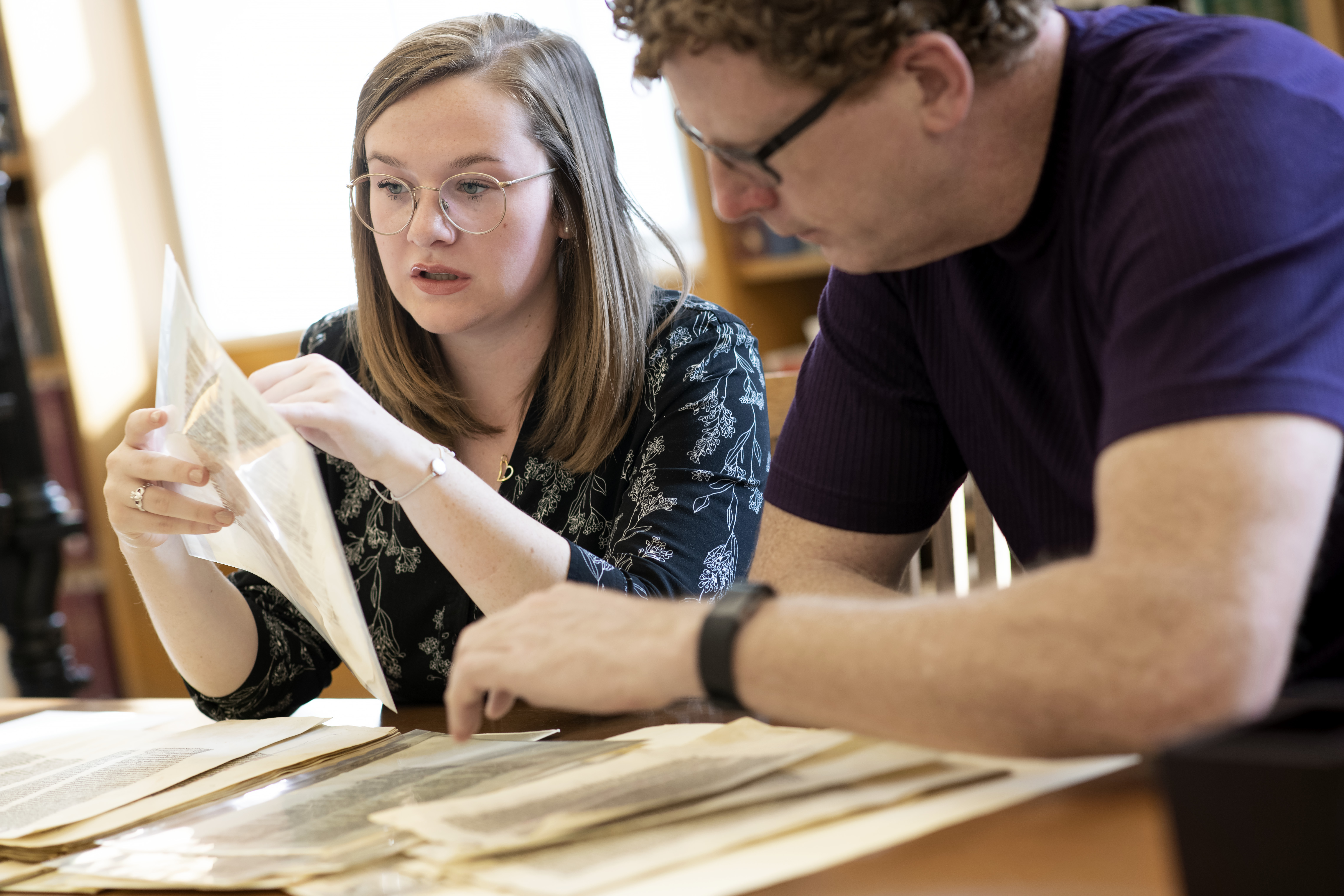 Student and faculty working over desk