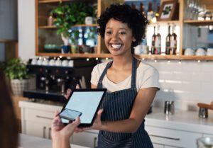 Happy woman, tablet and mockup screen for payment, ecommerce or tap in electronic purchase at cafe. Female waitress and customer with technology display for fintech transaction or paying at checkout.