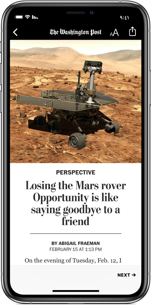 في الجزء العلوي من الشاشة يظهر زر Back واسم المنشور وزر Text Size وزر Share. وأسفل ذلك توجد صورة ذات صلة بالمقال، وبعدها عنوان المقال وجزء من أول سطر من نص المقال.