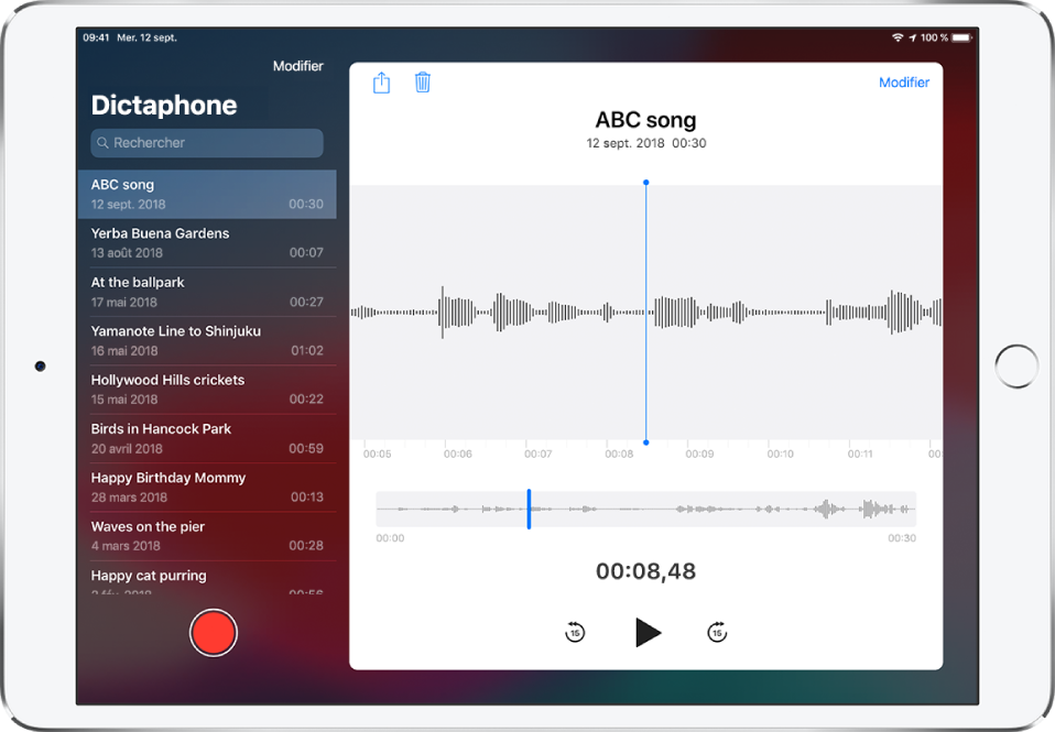 La liste Mémos vocaux avec un enregistrement sélectionné en haut. Il comporte une tête de lecture, ainsi qu’une chronologie affichée sous la forme d’onde. Au-dessus figurent les boutons Partager, Supprimer, Modifier et Élaguer. Sous la chronologie figurent les boutons Retour de 15 secondes, Lecture et Avance de 15 secondes. Sur la gauche figure une liste d’autres enregistrements pouvant être ouverts d’une simple pression du doigt.