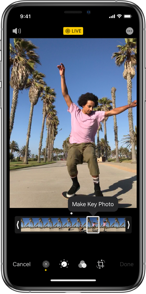 Ekranas „Live Photo“, kurio ekrane pateikta nuotrauka „Live Photo“. Mygtukas „Live“ pateikiamas viršuje centre, o mygtukas „Sound“ – viršuje kairėje. Po „Live Photo“ yra kadro peržiūra su aktyviu „Make Key Photo“ mygtuku. Abiejuose kadrų žiūryklės galuose pateikiamos dvi juostos, kurias naudojant galima apkarpyti „Live Photo“.