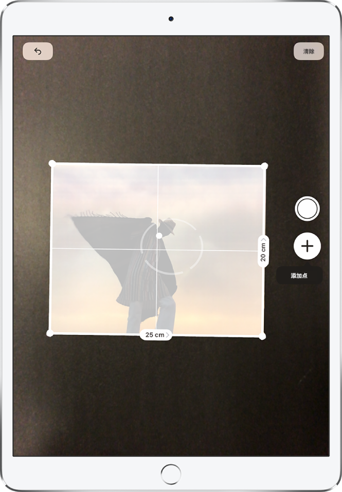 一张纸质照片正在被测量,其右侧和底部边缘分别显示了其尺寸。“拍照”按钮位于右边缘中间附近。
