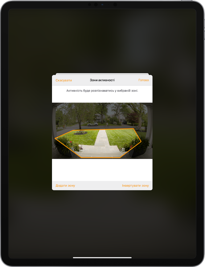 Екран iPad, на якому відображається зона активності на зображенні, знятому камерою дверного дзвінка. Зона активності включає ґанок і доріжку, проте не охоплює вулицю та дорогу. Над зображенням відображаються кнопки «Скасувати» й «Готово». Унизу відображаються кнопки «Додати зону» й «Інвертувати зону».
