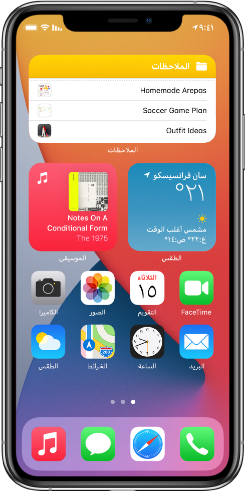 شاشة الـ iPhone الرئيسية. في النصف العلوي من الشاشة توجد أدوات الملاحظات والطقس والموسيقى. في النصف السفلي من الشاشة توجد التطبيقات.