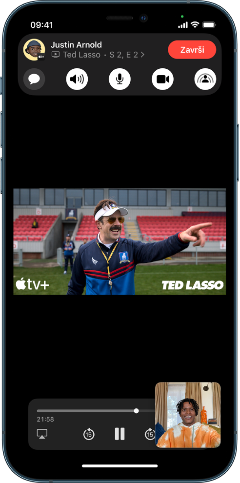 FaceTime poziv s prikazom AppleTV+ video sadržaja koji se dijeli u pozivu. Kontrole FaceTimea prikazuju se na vrhu zaslona, videozapis se reproducira odmah ispod kontrola, a kontrole reprodukcije nalaze se na dnu zaslona.