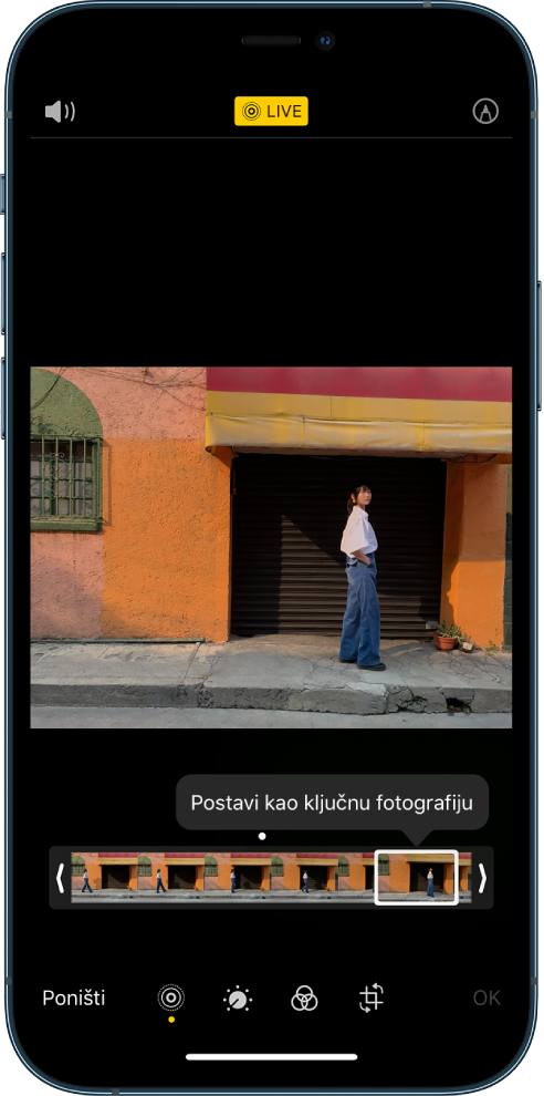 Live Photo zaslon s Live Photo u sredini. Tipka Live nalazi se gore u sredini, a tipka Zvuk gore lijevo. Ispod fotografije nalazi se preglednik kadrova s aktivnom tipkom Postavi kao ključnu fotografiju. Na bilo kojem kraju preglednika kadrova nalaze se dvije strelice koje vam omogućuju odrezati Live Photo.