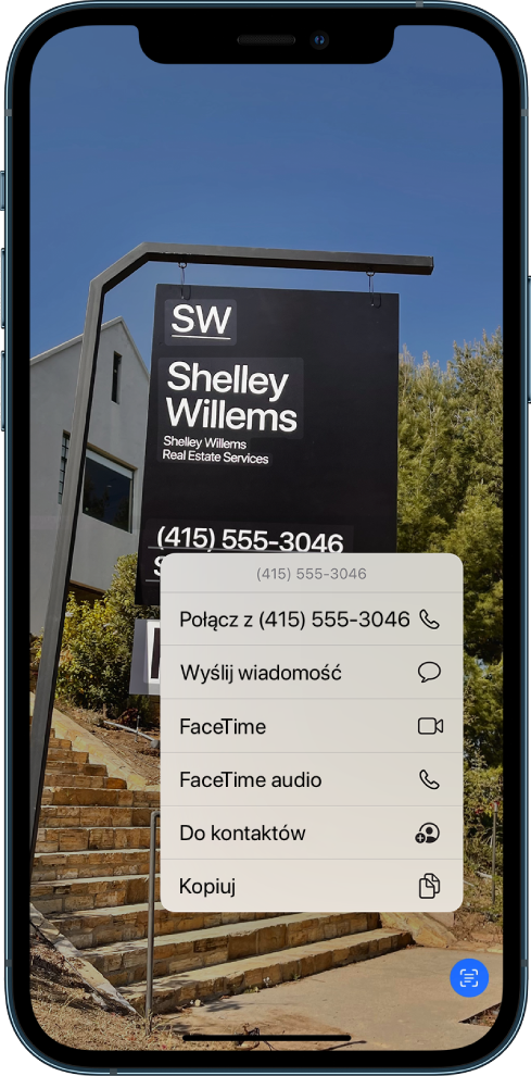 Zdjęcie otwarte na pełnym ekranie. Na zdjęciu widoczny jest znak zawierający tekst oraz numer telefonu. Numer telefonu jest zaznaczony i widoczne są następujące opcje: Połącz, Wyślij wiadomość, FaceTime, FaceTime audio, Do kontaktów oraz Kopiuj.