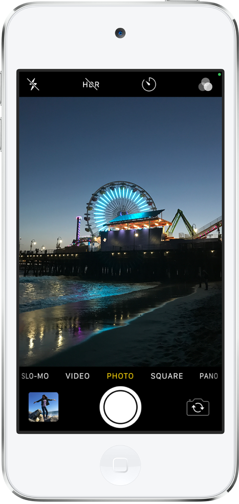 Kamera dalam mode Foto, dengan mode lain ke kiri dan kanan di bawah penampil. Tombol untuk Kilat, HDR, Timer, dan Filter muncul di bagian atas layar. Tombol Penampil Foto dan Video ada di pojok kiri bawah. Tombol Ambil Gambar ada di tengah bawah, dan tombol Pemilih Kamera Belakang ada di pojok kanan bawah.