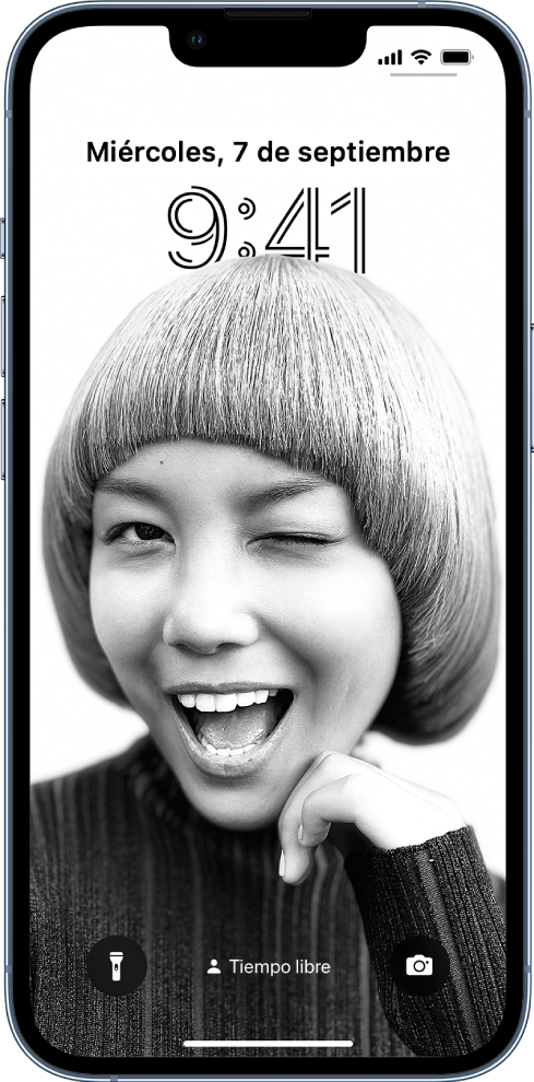 Pantalla de bloqueo con una imagen de fondo personalizada y una visualización de la hora y la fecha personalizadas. En la parte inferior de la pantalla, de izquierda a derecha, se encuentran: el botón Linterna, un modo de tiempo libre activado y el botón Cámara.