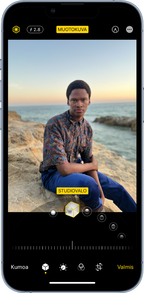 Muotokuvatilassa otetun kuvan muokkausnäyttö. Näytön ylävasemmalla ovat Valaistuksen voimakkuus ‑painike ja Syvyydensäätö-painike. Näytön yläreunan keskellä on Muotokuva-painike päällä, ja yläoikealla on Merkintä-painike. Kuva on näytön keskellä, ja sen alapuolella on liukusäädin muotokuvavalotehosteen valitsemiseen. Sen alapuolella on liukusäädin arvon säätämiseen. Näytön alareunassa vasemmalta oikealle lueteltuina ovat Kumoa-, Muotokuva-, Muokkaa-, Suodattimet-, Rajaa- ja Valmis-painikkeet.