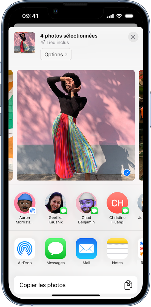 L’écran de partage avec une photo sélectionnée en haut, comme indiqué par la coche blanche dans un rond bleu. La ligne située sous la photo suggère des contacts avec qui partager cette dernière. D’autres options de partage sont proposées en dessous, notamment, de gauche à droite : AirDrop, Messages, Mail et Notes. En bas de l’écran se trouve le bouton « Copier les photos ».