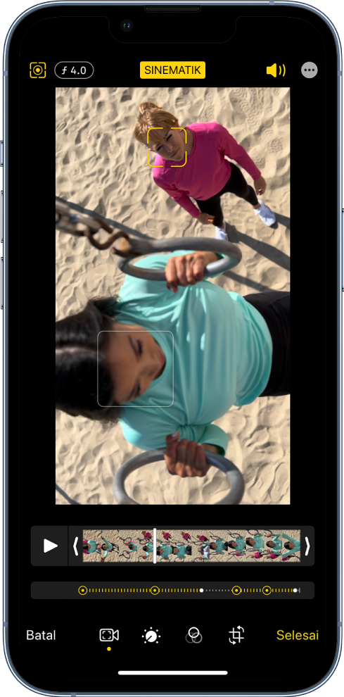 Skrin Edit video mod Sinematik dalam orientasi landskap. Di bahagian kiri atas skrin ialah butang Batal, butang Manual Sinematik dan butang Pelarasan Kedalaman. Di bahagian tengah atas skrin, butang Sinematik dipilih. Di bahagian kanan atas skrin ialah butang Kelantangan, butang Masuk Skrin Penuh dan butang Selesai. Video berada di tengah skrin dan terdapat bingkai di sekeliling subjek fokus. Di bawah video ialah pemapar bingkai yang memaparkan titik dalam video yang fokus subjek bertukar. Alat pengeditan berada di sebelah kanan skrin, dari atas ke bawah. Video, Laraskan Warna, Penapis dan Pangkas.