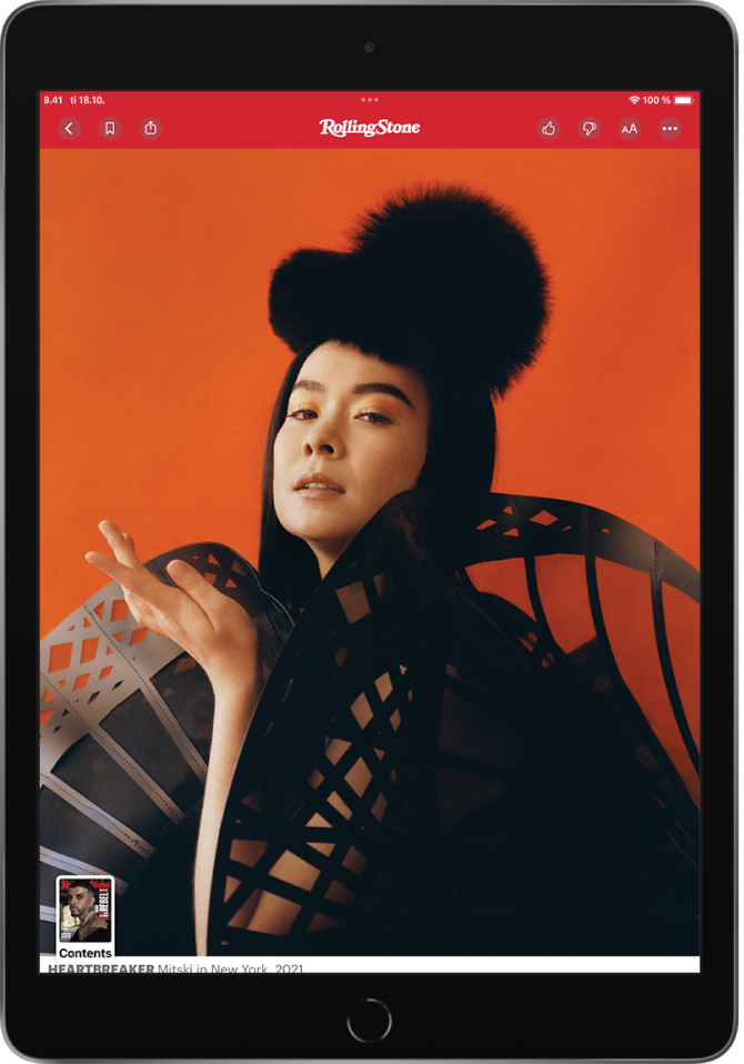 Näytössä näkyy aikakauslehden juttu. Vasemmassa yläkulmassa näkyvät Previous-, Bookmark- ja Share-painikkeet. Oikeassa yläkulmassa näkyvät Suggest More-, Suggest Less-, Text Size- ja More-painikkeet. Julkaisun nimi näkyy ylhäällä keskellä. Sen alla näkyy suuri kuva. Näytön vasemmassa alakulmassa on Contents-painike (aikakauslehden kansikuvan miniatyyri).