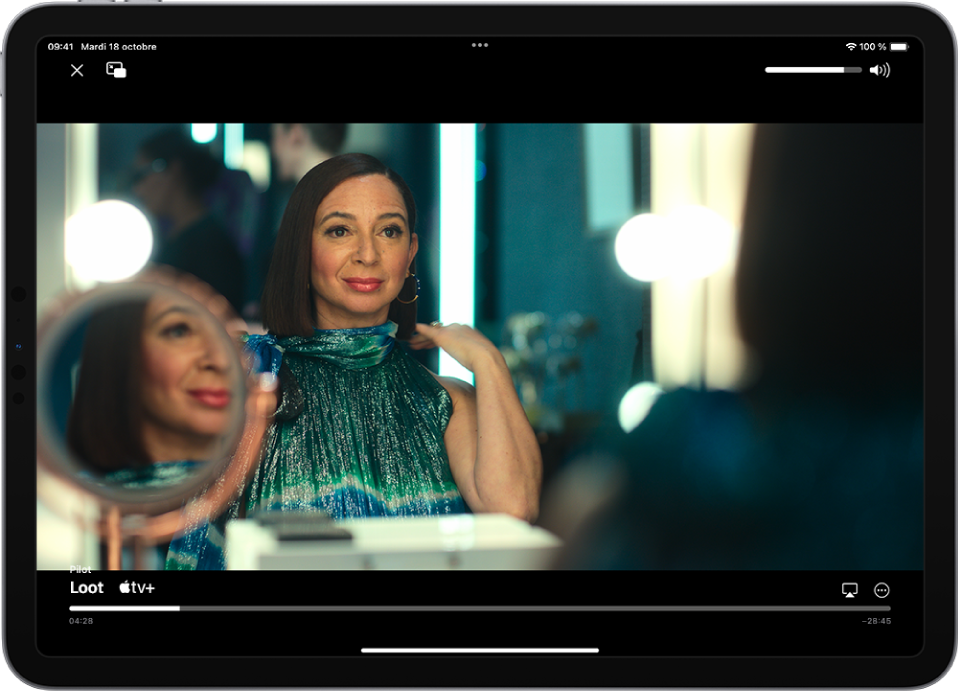 Une série est en cours de lecture et les commandes sont affichées. Les boutons Fermer et « Image dans l’image » se trouvent en haut à gauche. Le curseur de volume se trouve en haut à droite. En bas au centre se trouve un curseur que vous pouvez faire glisser pour ajuster la position de la vidéo ; le temps écoulé et le temps restant apparaissent sur chaque côté du curseur. En bas à droite se trouvent les boutons permettant de changer la destination de la vidéo et d’afficher d’autres commandes,