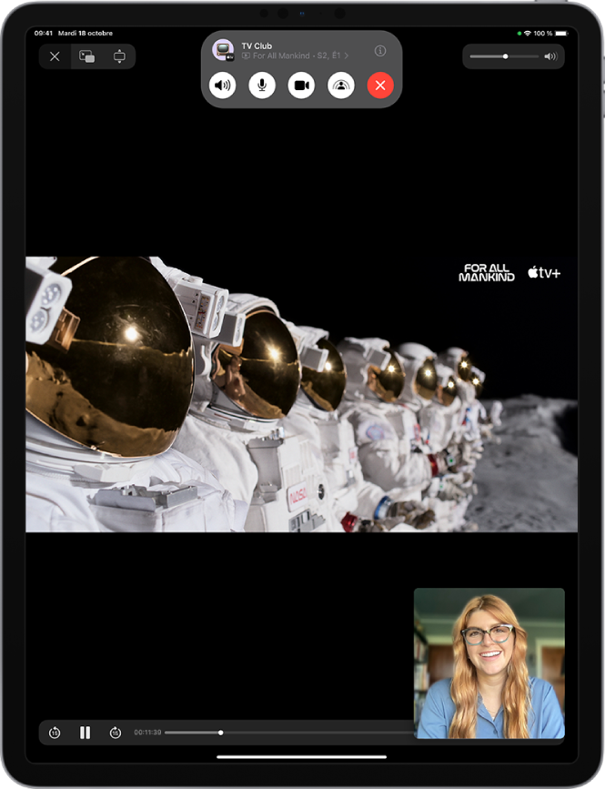 Un appel FaceTime affichant un contenu vidéo Apple TV+ en cours de partage lors de l’appel. En haut se trouvent les commandes FaceTime, notamment les boutons Audio, Micro, Caméra, SharePlay et Raccrocher. Au-dessus des commandes se trouvent l’identifiant Apple du groupe ou de l’interlocuteur, ainsi que le bouton Infos. La vidéo est en cours de lecture sous les commandes. Les commandes de lecture se trouvent en bas de l’écran.