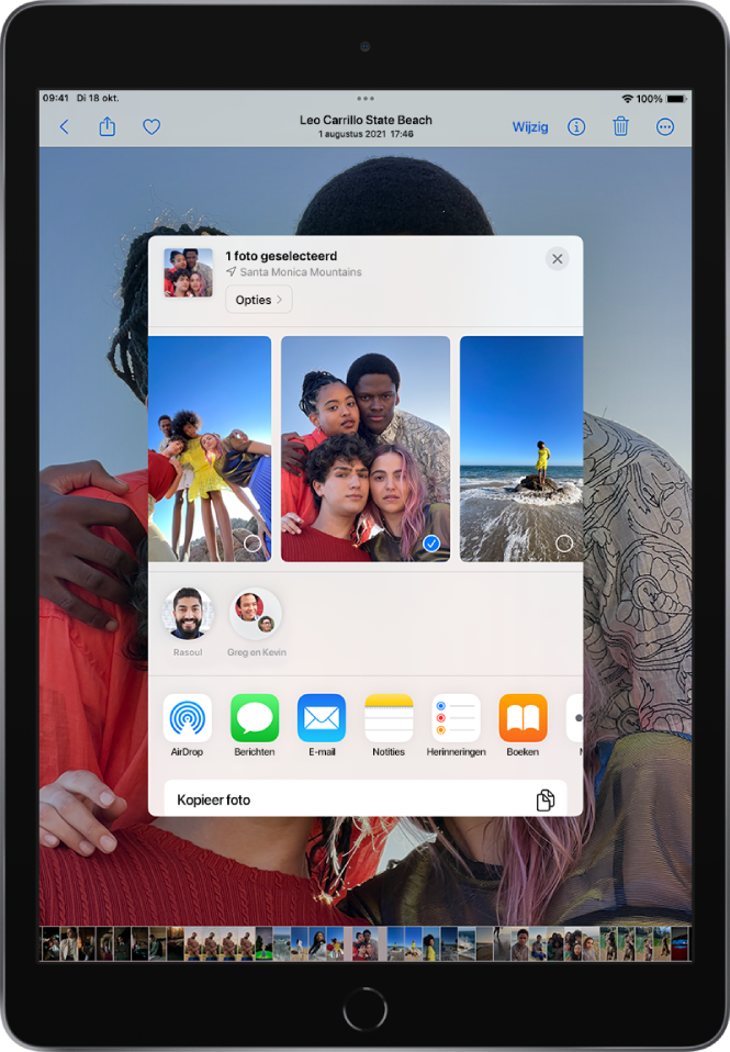 In het midden van het scherm bevindt zich het deelvenster voor foto's. Boven in het venster bevinden zich de foto's. Er is één foto geselecteerd, aangegeven met een vinkje. In de rij onder de foto's staan suggesties voor recente contactpersonen met wie je kunt delen. Onder de voorgestelde contactpersonen staan van links naar rechts de volgende deelopties: AirDrop, Berichten, E‑mail, Notities, Herinneringen en Boeken. Onder in het deelscherm staat een rij met taken. Van boven naar beneden worden de taken 'Kopieer foto' en 'Zet in gedeeld album' weergegeven.