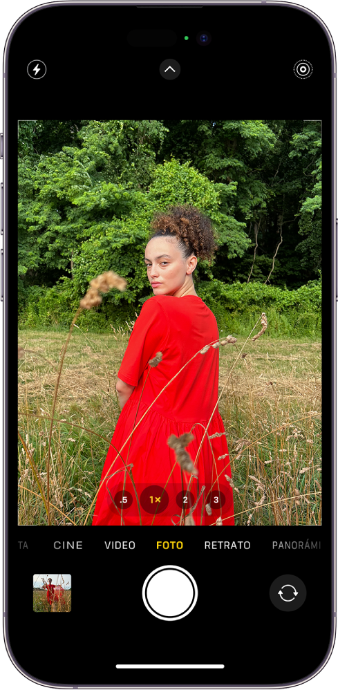 La cámara en el modo Foto, con los otros modos a la derecha e izquierda debajo del visor. En la parte superior de la pantalla se encuentran los botones Flash, Controles de la cámara y Live Photos. El visor de fotos y videos se encuentra en la esquina inferior izquierda. El botón Tomar foto está en la parte central inferior y el botón Selector de cámara posterior se encuentra en la esquina inferior derecha.