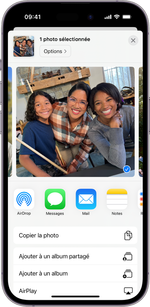Une photo sélectionnée est affichée dans la moitié supérieure de l’écran de l’iPhone, avec des options de partage en dessous : AirDrop, Messages, Mail et Notes. Sous ces options de partage se trouvent d’autres actions que vous pouvez effectuer sur la photo, notamment Copier la photo, Ajouter à un album partagé, Ajouter à un album et AirPlay.