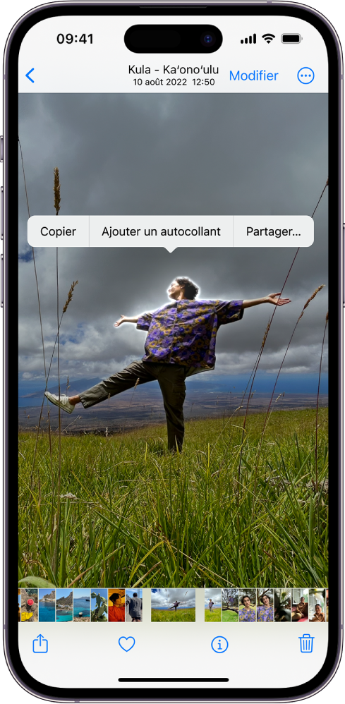L’app Photos est ouverte sur la photo d’une personne. La personne est sélectionnée, et l’option « Ajouter des autocollants » est disponible dans le menu situé au-dessus.