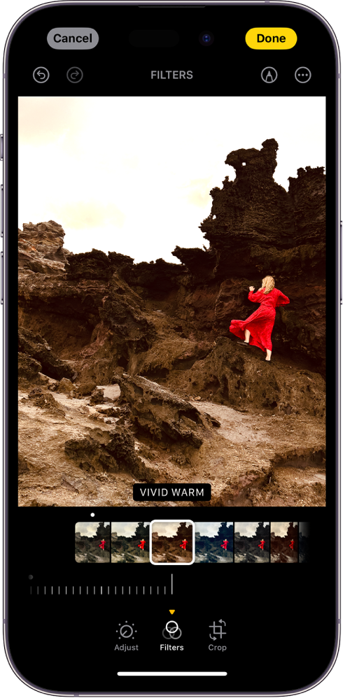 Ekrani Edit me një fotografi në qendër. Në fund të ekranit, nga e majta në të djathtë, janë butonat Adjust, Filters dhe Crop. Është zgjedhur butoni Filters dhe ka një rrëshqitës për të rregulluar intensitetin e filtrit. Butoni Cancel është në këndin e sipërm majtas të ekranit dhe butoni Done është në këndin e sipërm djathtas të ekranit. Gjithashtu në krye të ekranit, nga e majta në të djathtë, janë butonat Undo, Redo, Filters, Markup dhe Plug-ins.