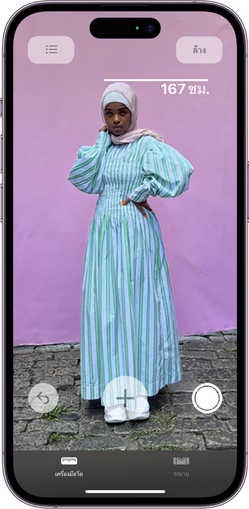 ส่วนสูงของคนถูกวัดในแอปเครื่องมือวัด โดยมีส่วนสูงแสดงอยู่ที่ด้านบนศีรษะของคนนั้น ปุ่มถ่ายรูปบริเวณมุมขวาล่างถูกกดอยู่เพื่อถ่ายรูปของการวัด ตัวบ่งชี้กล้องใช้งานอยู่สีเขียวแสดงอยู่ที่ด้านบนสุด