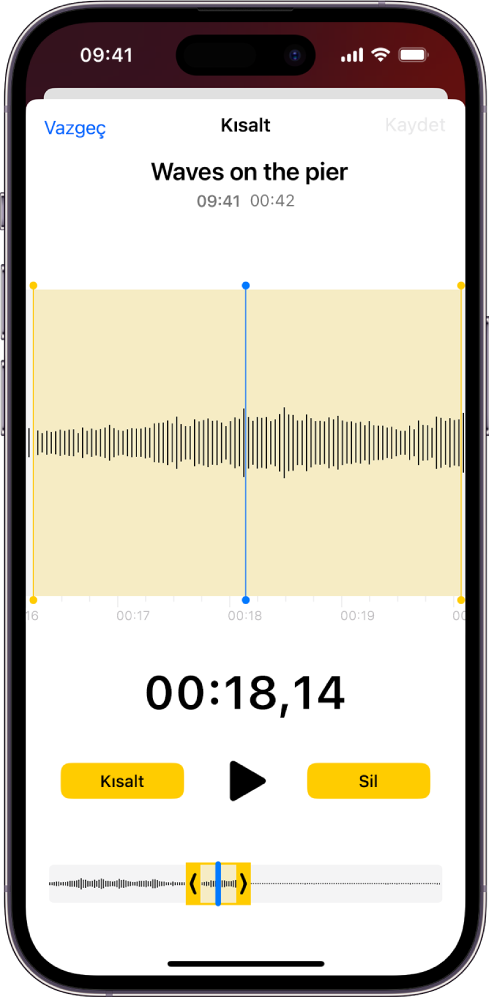 Ekranın en altındaki ses dalgasının bir bölümünü çevreleyen sarı kısaltma tutamaklarıyla birlikte düzenlenen bir kayıt. Çal düğmesi ve kayıt sayacı dalga biçiminin alt tarafında görünüyor. Kısaltma tutamakları Çal düğmesinin altında. Çal düğmesinin yanında, tutamakların dışındaki kayıt bölümünü silmek için Kısalt düğmesi ve tutamakların içindeki kayıt bölümünü silmek için Sil düğmesi bulunuyor.