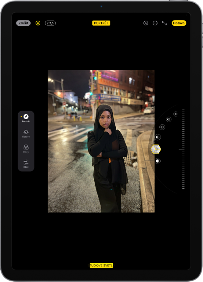 Obrazovka Úpravy s fotkou pořízenou v režimu Portrét. Fotka se nachází uprostřed displeje a vpravo jsou vidět volby efektů nasvícení portrétu. Je vybraný filtr Studiové světlo. Vedle něj se zobrazuje jezdec pro úpravy intenzity filtru. Na levé straně obrazovky se nacházejí tlačítka Portrét, Upravit, Filtry a Ořez. Tlačítko Portrét je vybrané.