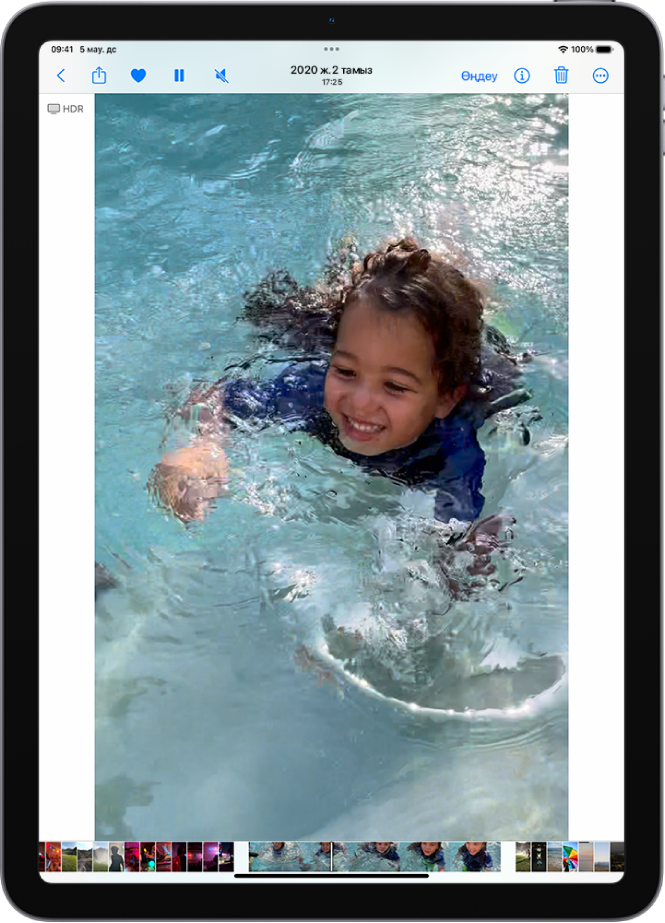 «Фото» қолданбасының видео ойнатқышы экранның ортасында және видео ойнатылып жатыр. Экранның төменгі жағында кадрды қарау құралы видео кадрларды солдан оңға қарай көрсетеді және индикатор экранда видеоның қай кадры ойнатылып жатқанын көрсетеді.